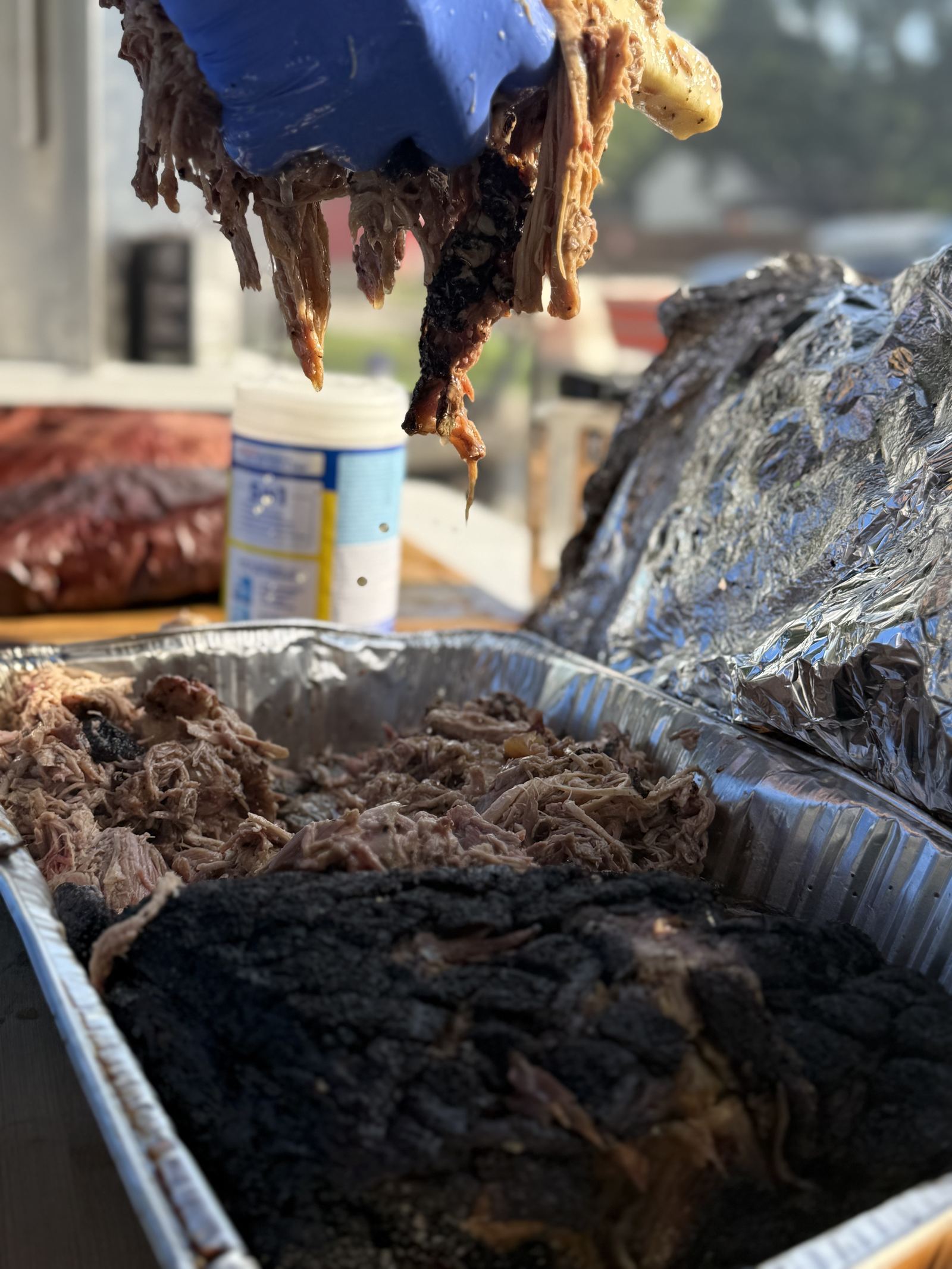 Pulled pork being lifted from the pan